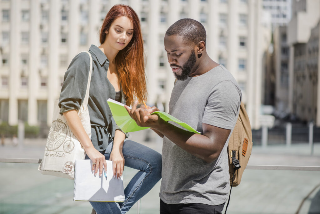 a student studying in abroad showing the fellow student an assignment assigned by their lecturer